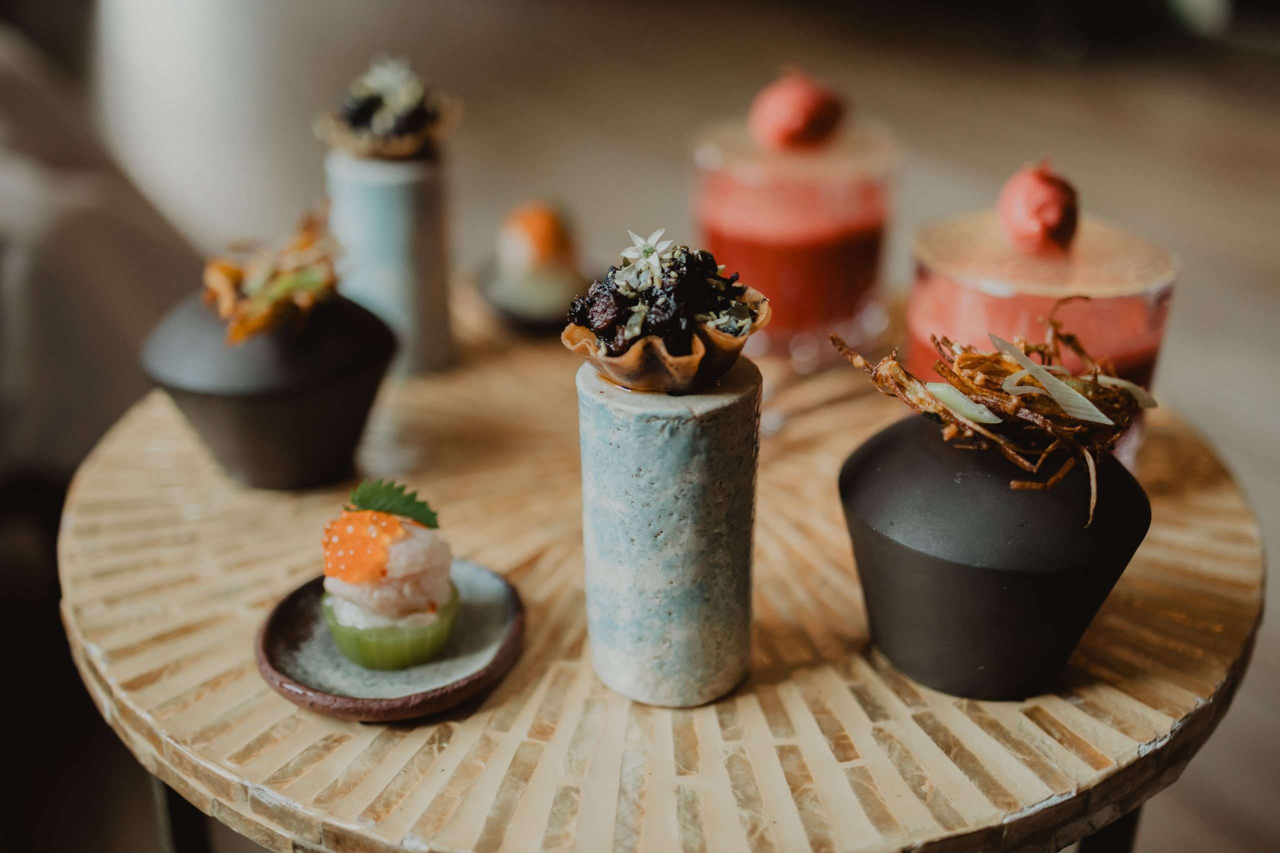 Kamayan Deux tables en bois dressées avec le couvert dans le restaurant gastronomique Maison Nipa.