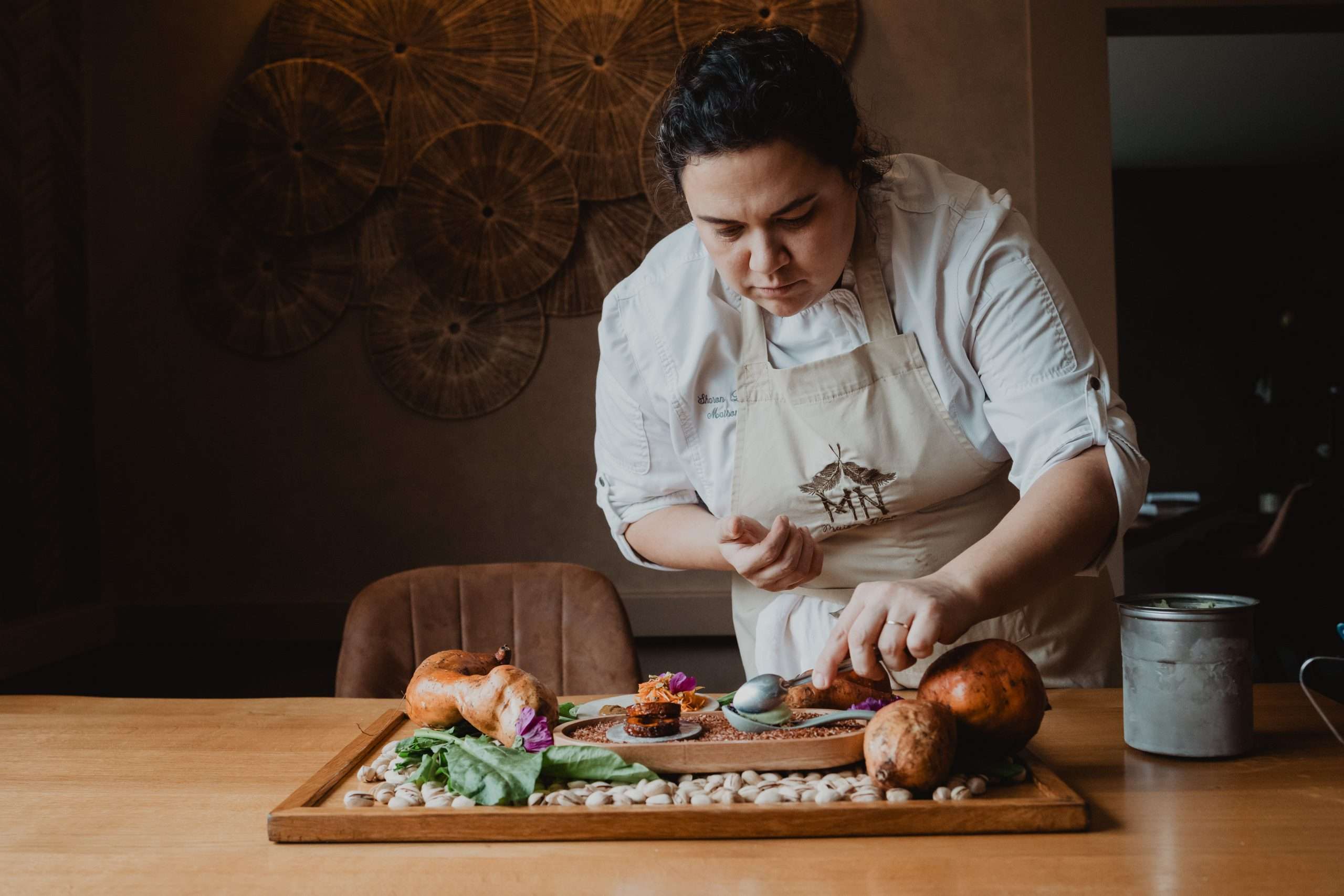 Assiette de nourriture gastronomique avec un verre de vin blanc, sur fond noir, présentant une esthétique raffinée.